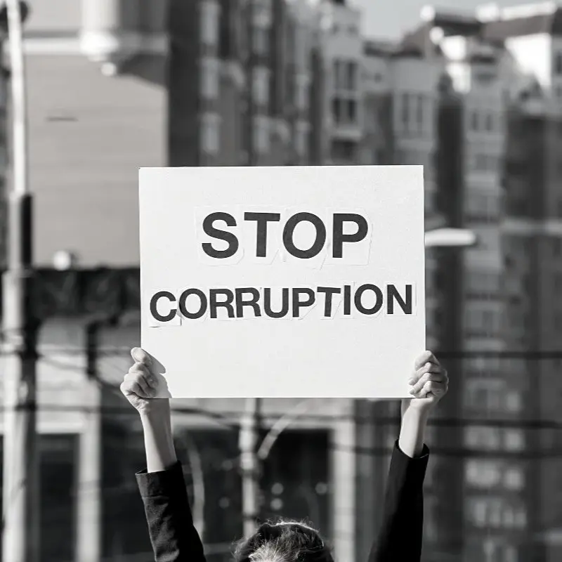 A person holding a sign with Stop Corruption written on it